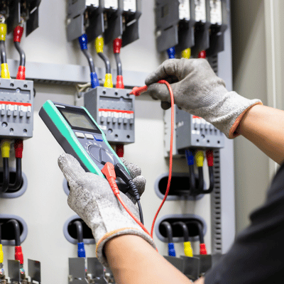 Commercial Electrician Services For Parking Lot Lighting 1 Technician uses multimeter on control panel during commercial electrician services for troubleshooting circuits